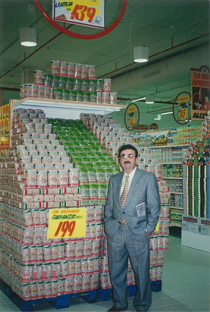 Domingo Racionero junto a una exposición de paquetes de legumbres MIAU en un supermercado